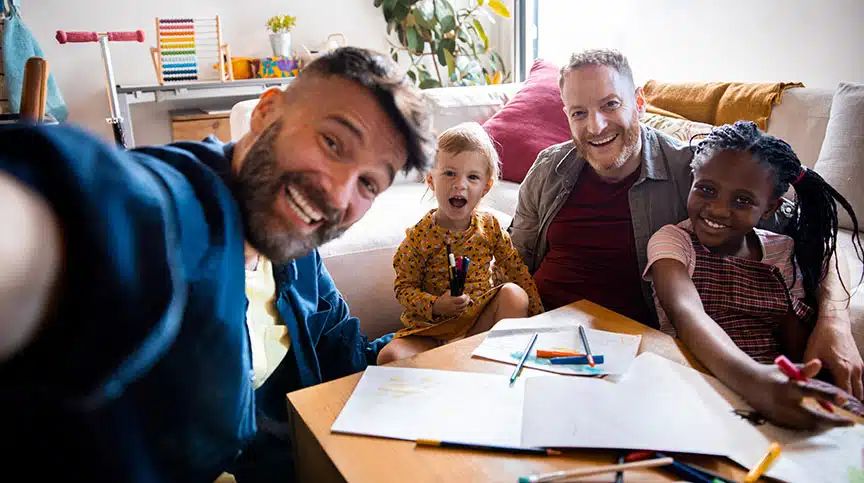 Ein Selfie von zwei berufstätigen Vätern, die mit ihren Kindern spielen.